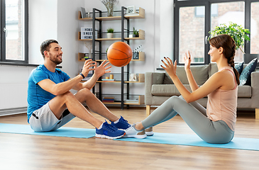 Image showing happy couple exercising with ball at home
