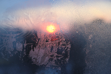 Image showing Ice pattern and water drops on glass on a sunny winter morning