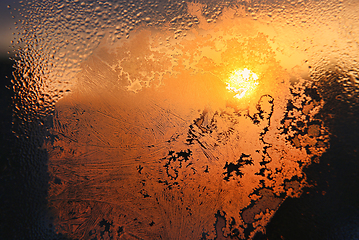 Image showing Ice patterns, water drops and sunlight on a window glass