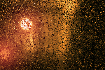 Image showing Water droplets on a window with city lights