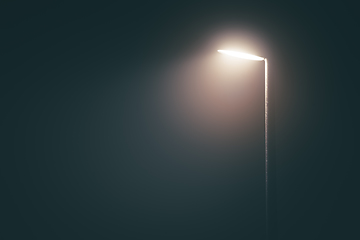 Image showing Streetlight post with bright light in a misty fog