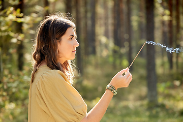 Image showing woman or witch performing magic ritual in forest