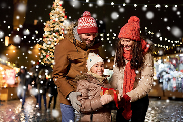 Image showing happy family with gift at christmas market in city