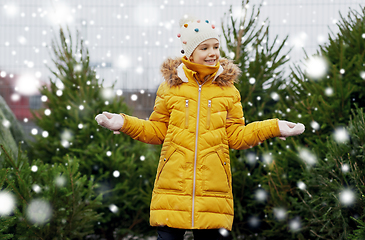 Image showing little girl choosing christmas tree at market