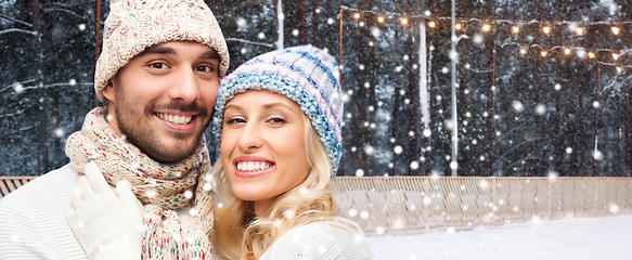 Image showing happy couple hugging on outdoor ice skating rink