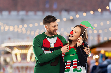 Image showing couple in sweaters with christmas party props