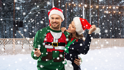 Image showing happy couple in christmas sweaters taking selfie