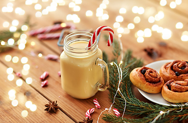 Image showing eggnog with candy cane in mug and cinnamon buns