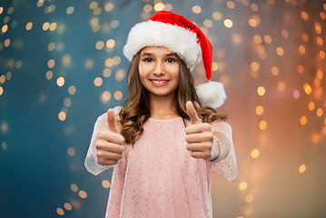 Image showing happy teenage girl showing thumbs up on christmas