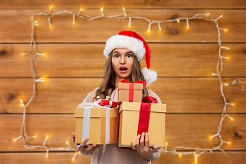 Image showing teenage girl in santa hat with christmas gift