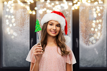 Image showing happy teenage girl in santa hat on christmas