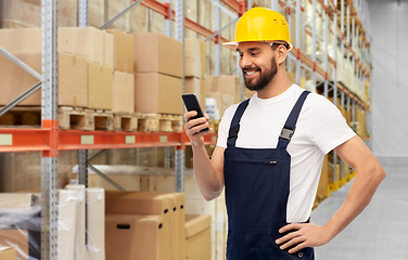 Image showing happy male worker with smartphone at warehouse