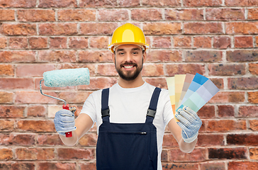 Image showing male builder with paint roller and color palettes