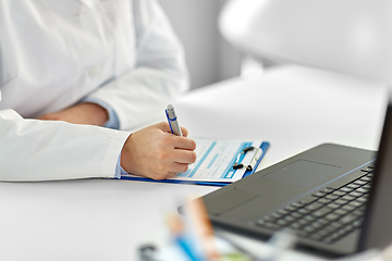 Image showing doctor with laptop and medical report at hospital