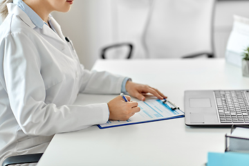 Image showing doctor with laptop and medical report at hospital