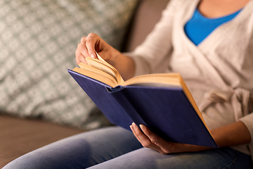 Image showing close up of young woman reading book at home