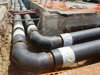 Image showing Laying heating pipes in a trench at construction site.