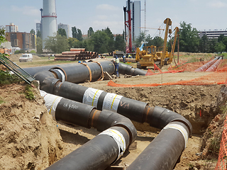 Image showing Laying heating pipes in a trench at construction site.