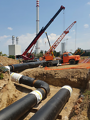 Image showing Laying heating pipes in a trench at construction site.
