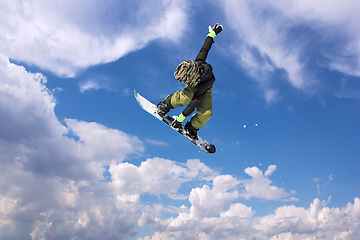 Image showing Snowboarder in action jumping against blue sky