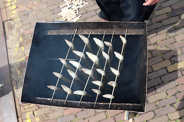 Image showing Traditional smoked eels, fish in a smoking in metal barrel