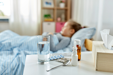 Image showing medicine for sick little girl lying in bed at home