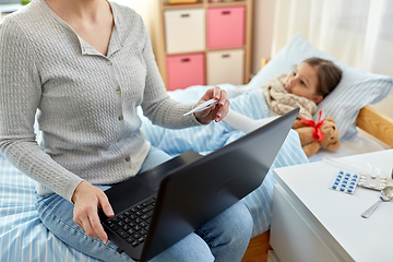 Image showing mother measuring temperature of sick daughter