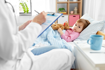 Image showing doctor with clipboard and sick girl in bed at home