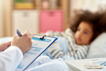 Image showing doctor with clipboard and sick girl in bed at home