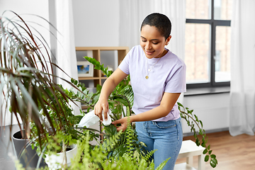 Image showing happy african american woman cleaning houseplant