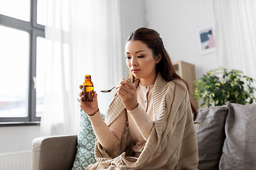 Image showing sick asian woman taking medicine at home