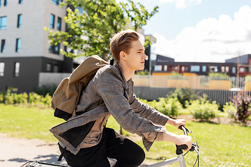 Image showing young man riding bicycle on city street