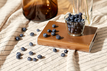 Image showing cup of blueberry, book and dried flowers in vases