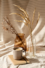 Image showing cup of coffee, diary and dried flowers in vases