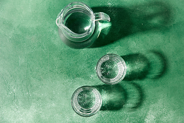 Image showing two glasses and jug with water on green background