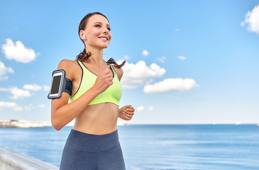 Image showing woman with earphones and smartphone running