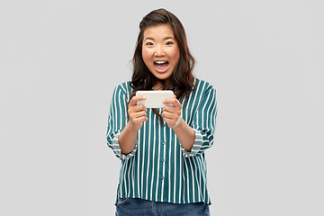 Image showing happy asian woman using smartphone