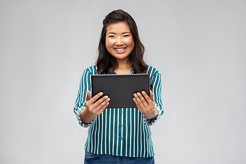 Image showing happy asian woman using tablet computer