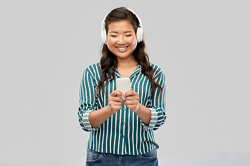 Image showing happy asian woman in headphones listening to music