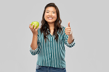 Image showing happy smiling asian woman holding green apple