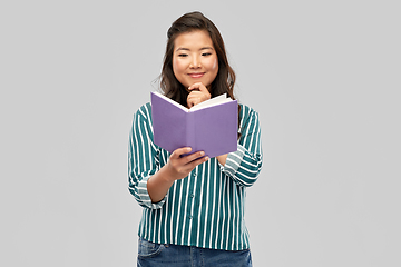 Image showing happy asian woman reading book