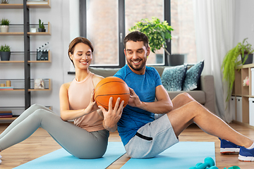 Image showing happy couple exercising with ball at home