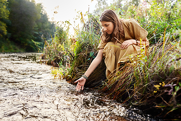 Image showing woman or witch performing magic ritual on river