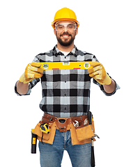 Image showing happy male worker or builder in helmet with level