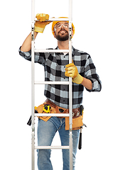 Image showing happy male builder in helmet climbing up ladder