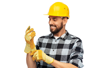 Image showing happy male worker or builder in helmet and gloves