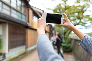 Image showing Taking photo by cellphone in old town of Japan