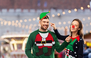 Image showing couple in sweaters with christmas party props