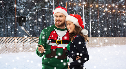 Image showing happy couple in christmas sweaters taking selfie