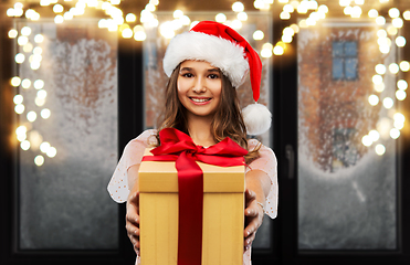 Image showing teenage girl in santa hat with christmas gift